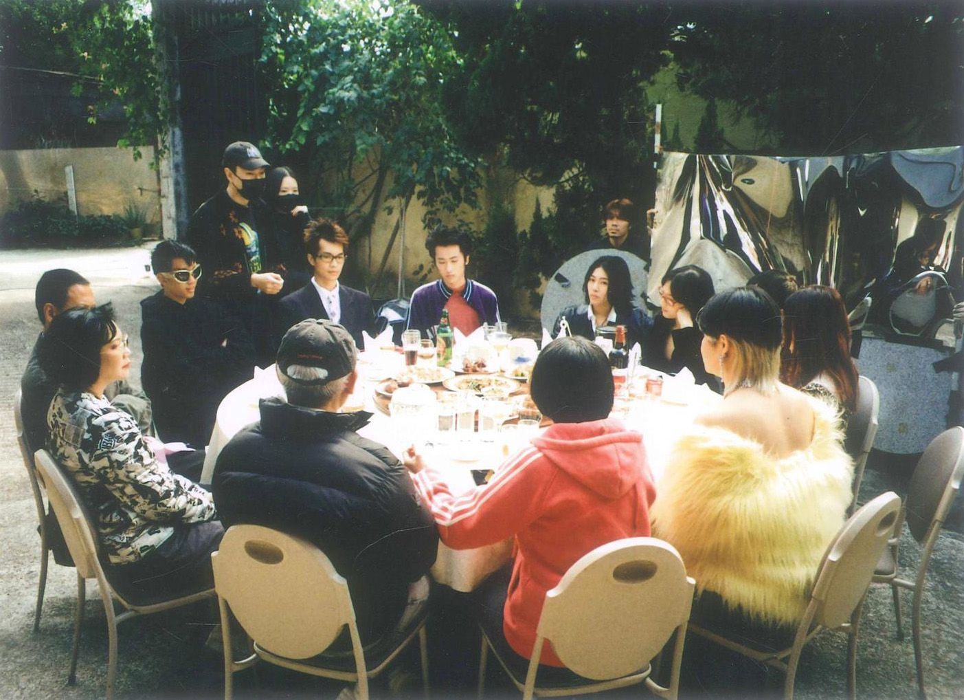 一群人坐在户外一张宴会圆桌。