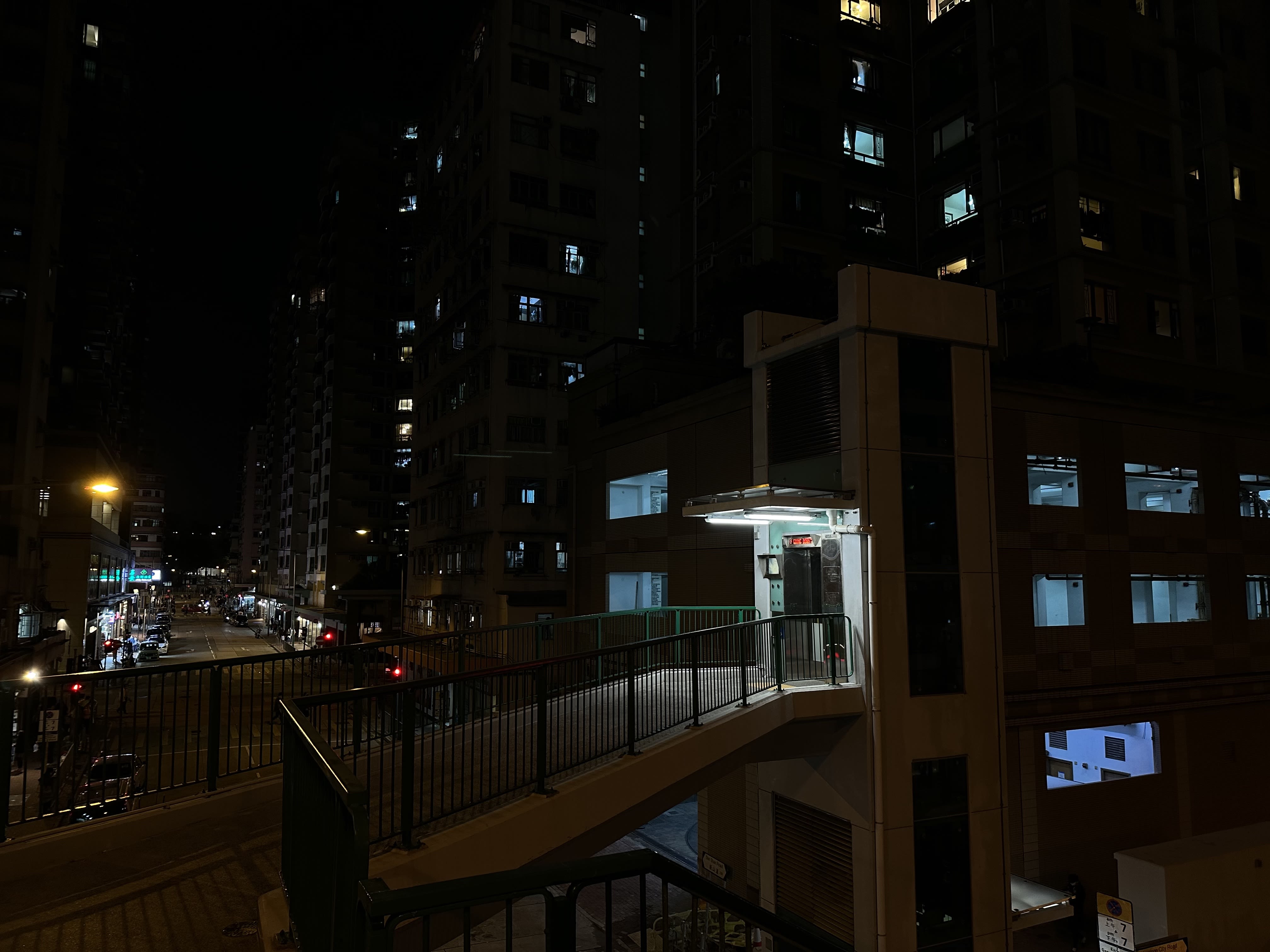 一部连接到行人天桥的升降机，在夜色中发光。