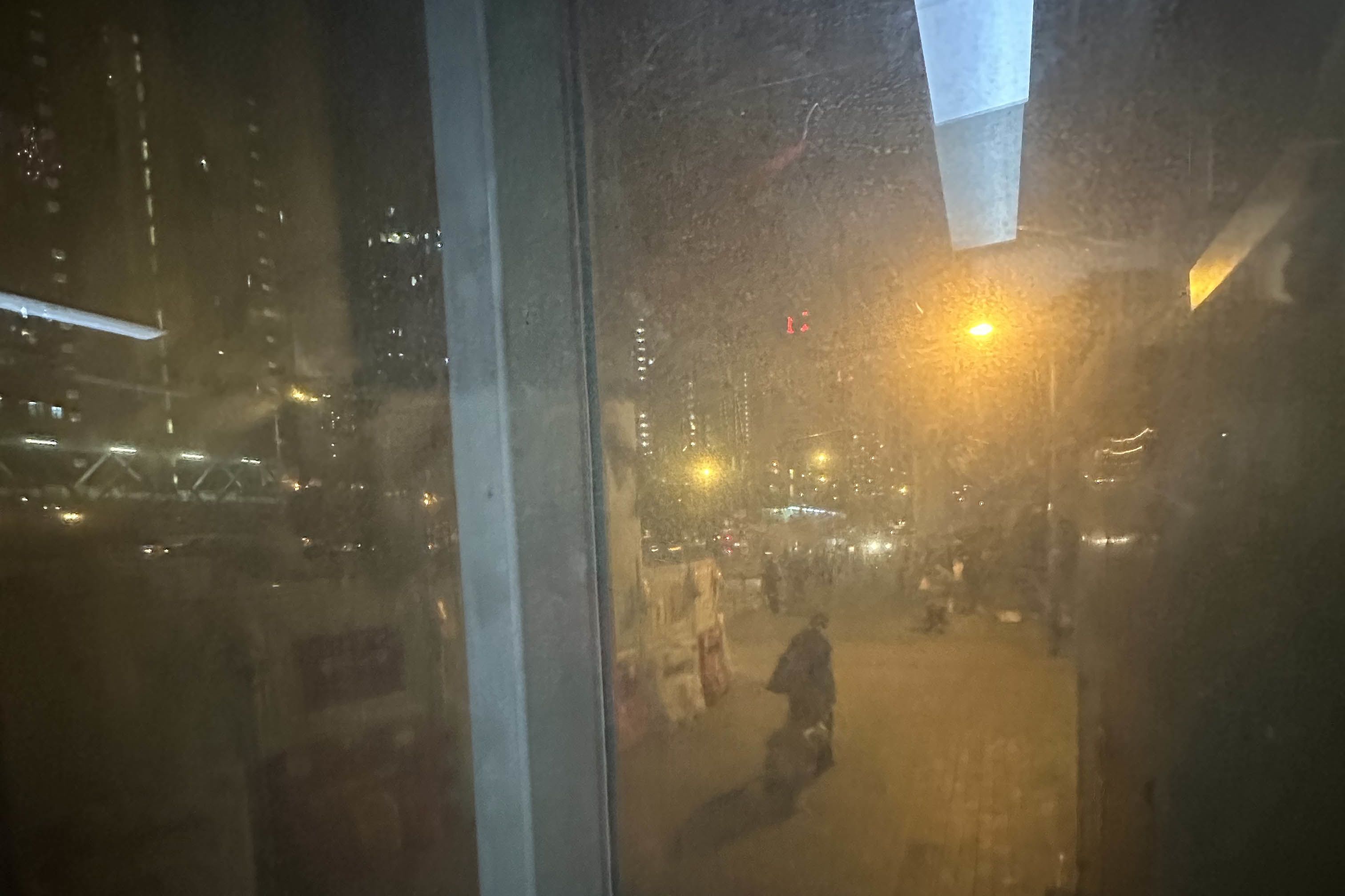 透过升降机的玻璃墙，看见香港街道的景色。