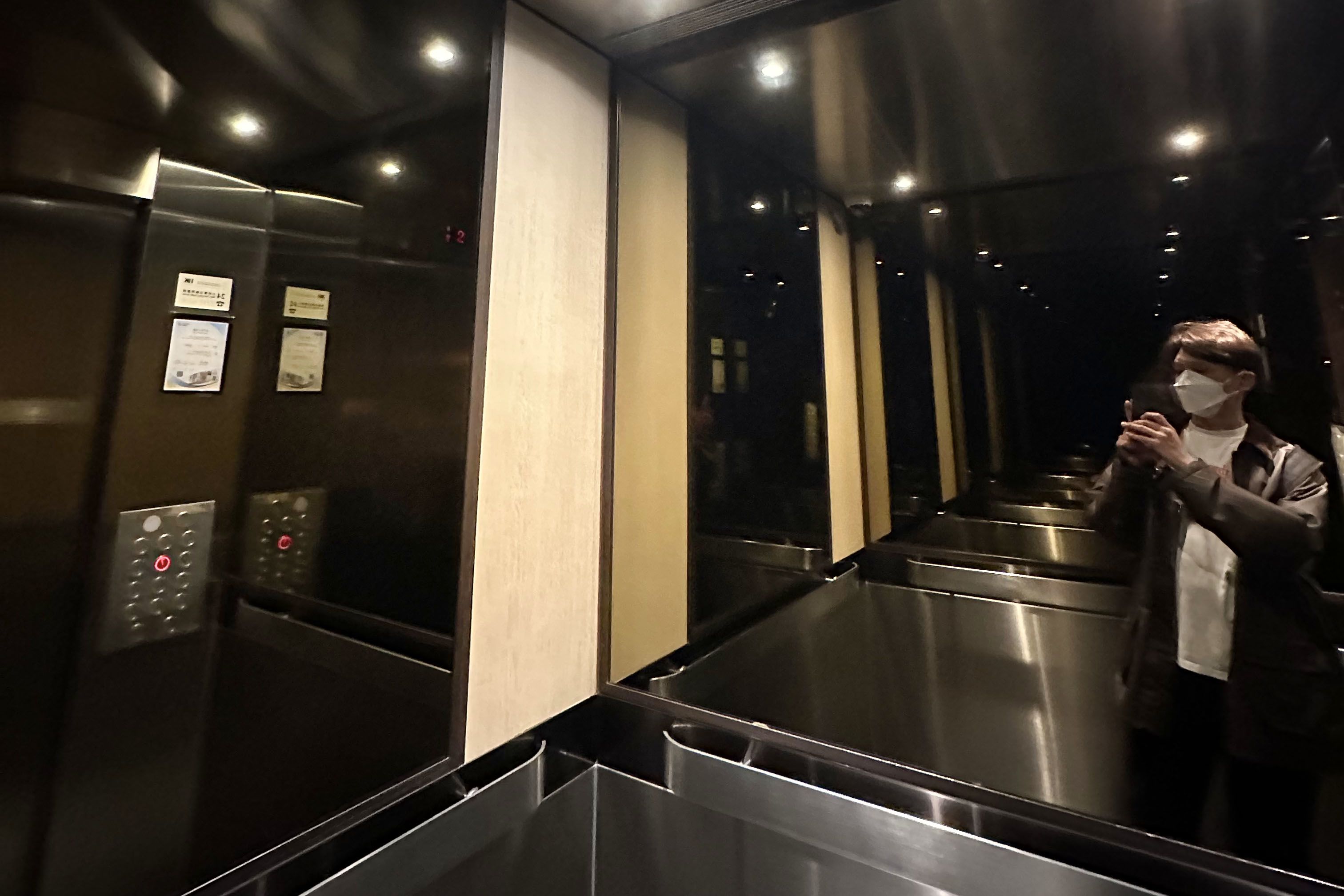 一个男人在升降机内的镜子拍摄自己的倒影。