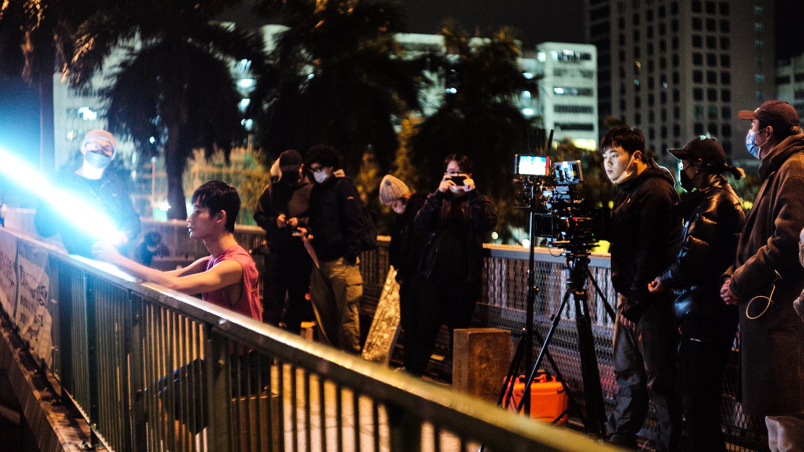 拍摄团队在行人天桥上为表演者打灯，准备开始拍摄。