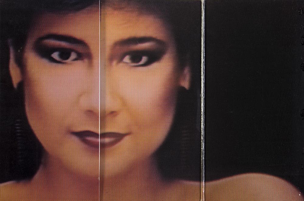 Cover of the vinyl album Legend of the Condor Heroes, with a pixelated, full frontal portrait of a face split in two halves. The left side is Jenny Tseng’s face and the right side is Roman Tam’s face. In this image the sleeve has been folded out further revealing Jenny Tseng's shoulder. 