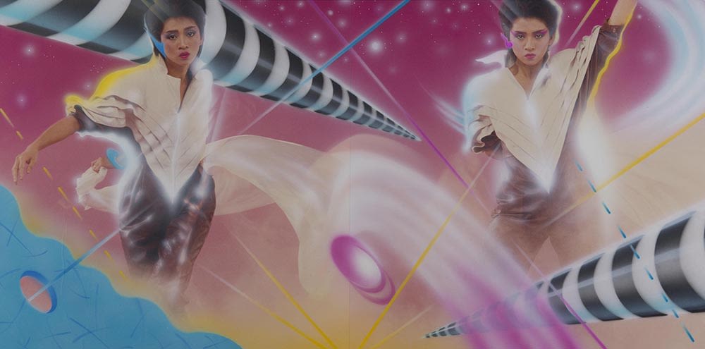 梅艳芳《飞跃舞台》黑胶唱片封套内页。以粉红色为主的跨页中，可见梅艳芳身穿黑白色迪斯科连身衣，背景各处都穿插显眼而色彩鲜艳的图形。