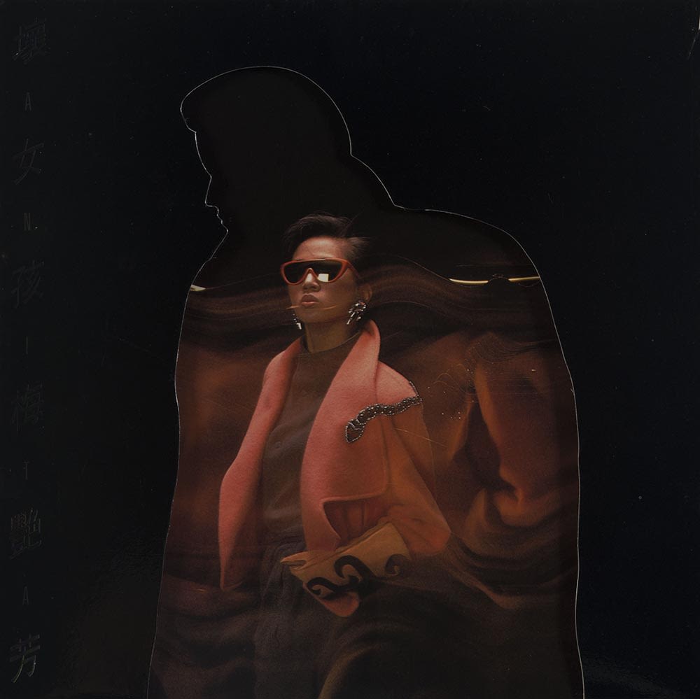 梅艳芳《坏女孩》黑胶唱片封套。梅艳芳站在中央，身穿橙红色外套、戴上太阳眼镜，被一个穿着大衣的镂空剪影包围着。