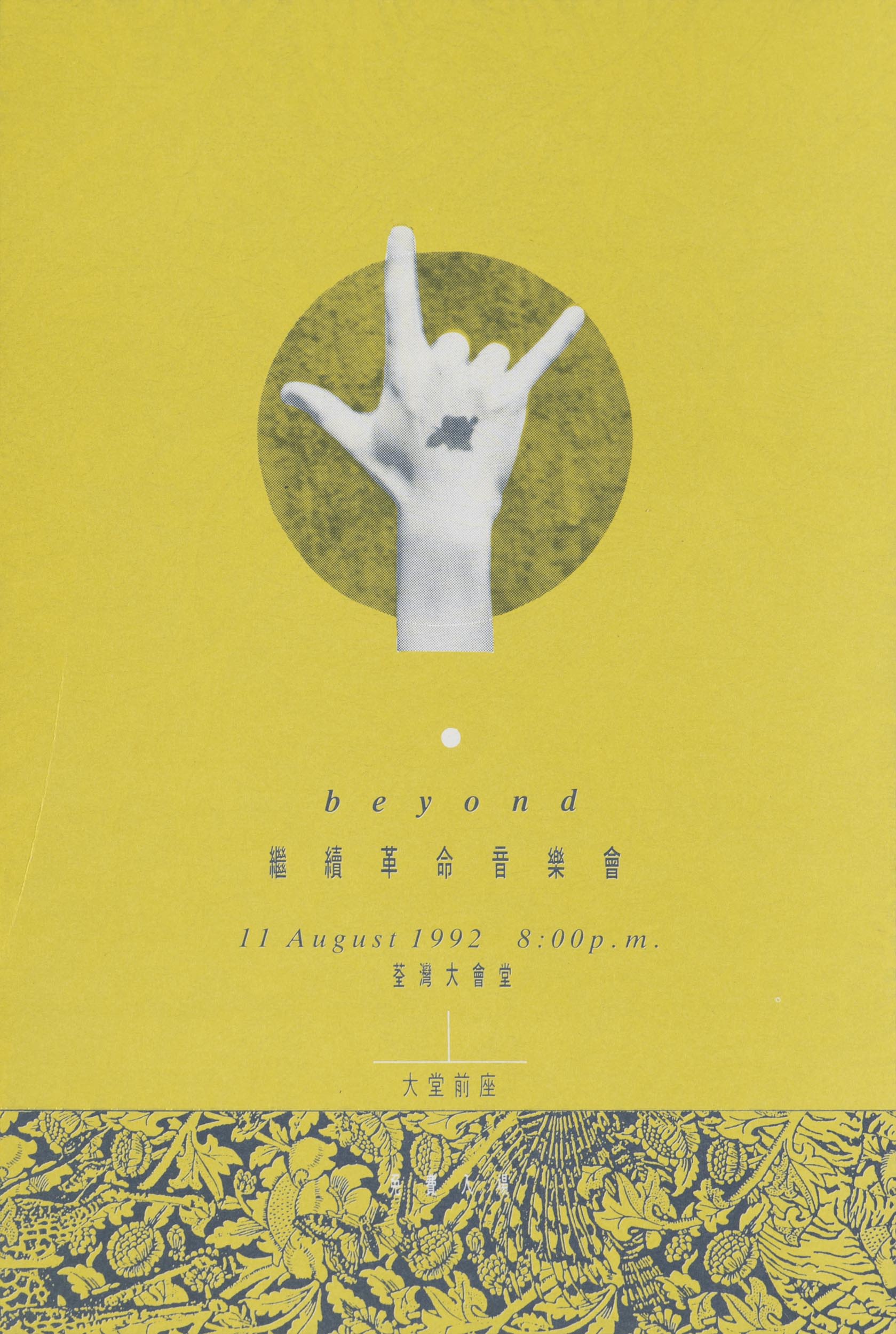 Front of a rectangular concert ticket for rock band Beyond. An image of a  ‘hand-horn’ gesture in white sits at the centre over a circular graphic element. Beneath it are several rows of the concert’s details. The main background is a muddy yellow, with a strip of dense foliage pattern with dark blue outlines at the bottom.