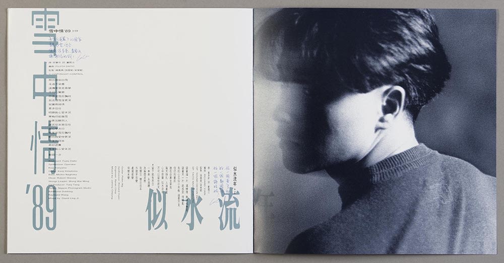 张国荣《Salute》镭射唱片歌词小册子跨页。左方有两首歌的歌词，浅蓝色的歌名和黑色的歌词以直书及横书方式排列。右页则是张国荣的黑白侧面肖像，他拧头往左方看去。