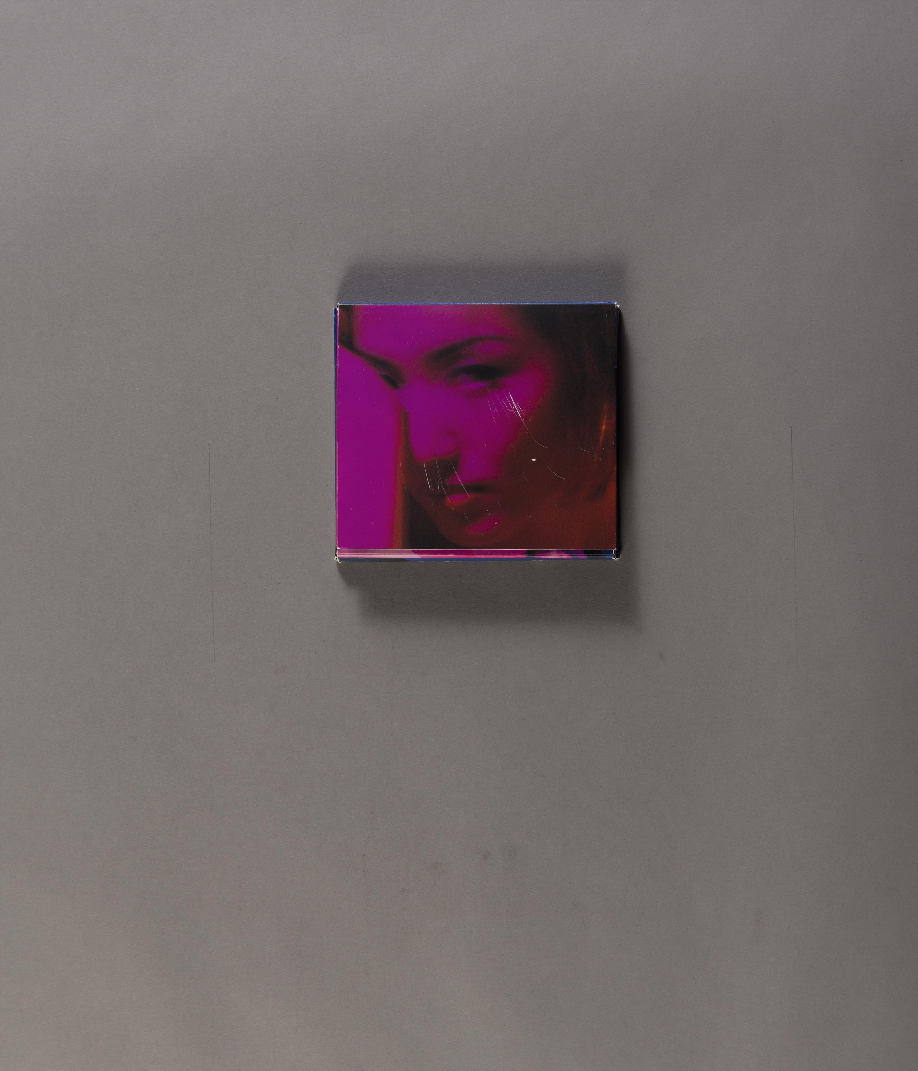 Back cover of Sammi Cheng’s CD album Decalogue, its image with an overall grainy effect. It has a headshot of the singer with a purple tone. She looks into the camera, her right hand covering her right eye.