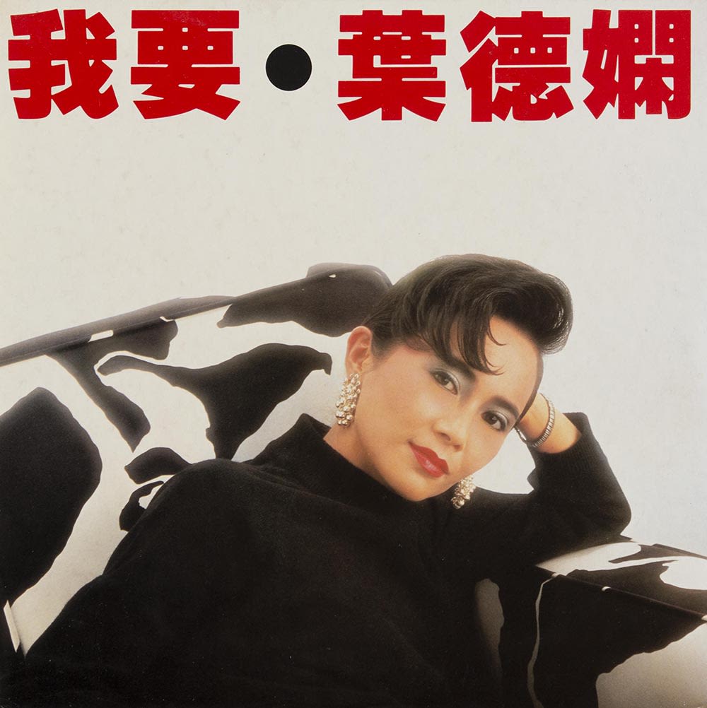 叶德娴《我要》黑胶唱片封面。顶部可见红色横书的标题，下方的叶德娴直视镜头，坐在黑白斑纹的沙发上。