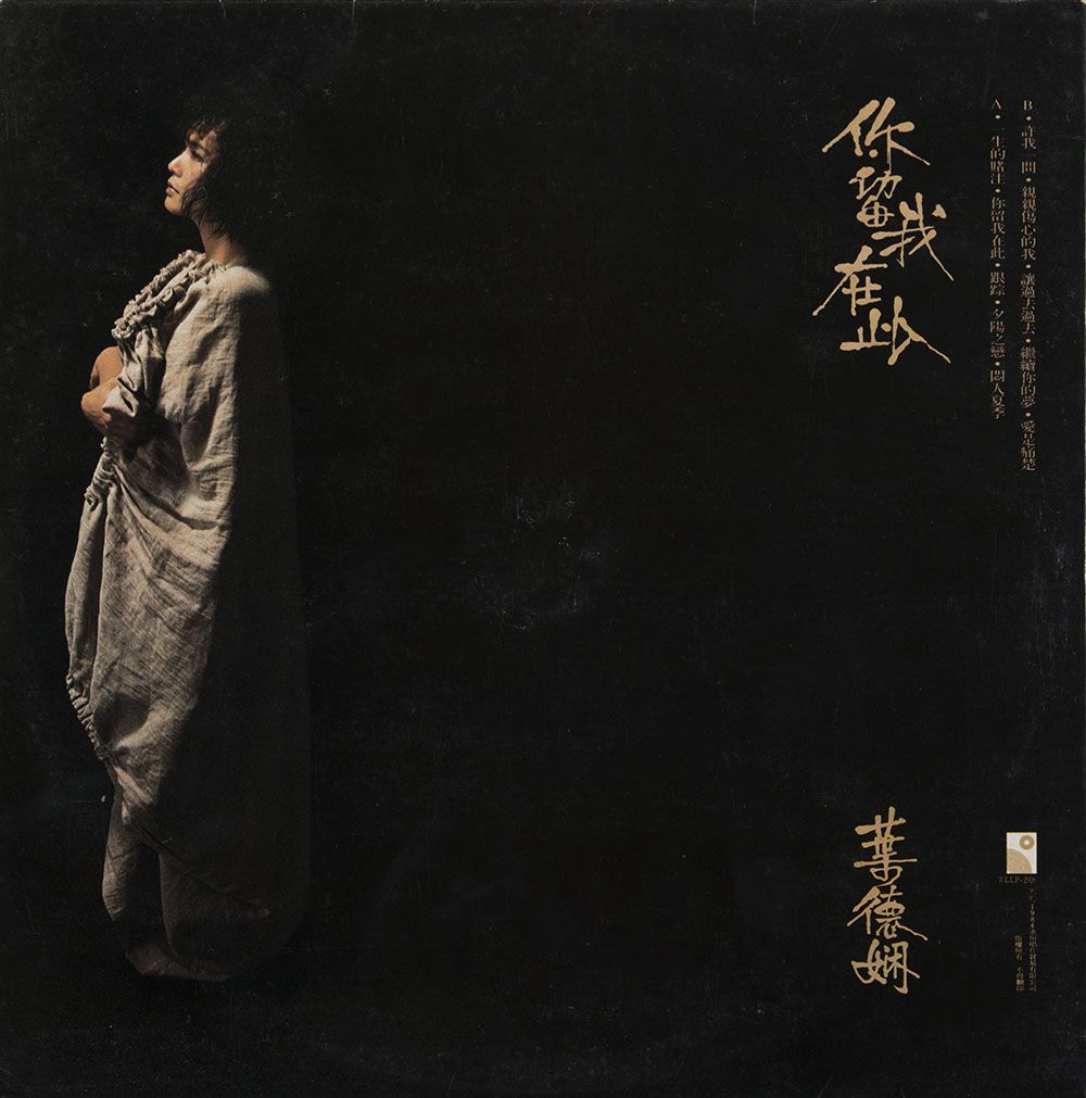 叶德娴《你留我在此》黑胶唱片封底，左方有叶德娴的全身照，身穿灰衣。金色直书的标题及曲目印在右上方，歌手名称则在右下方。