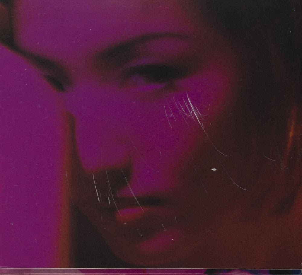 郑秀文《十诫》镭射唱片封底，照片带有颗粒效果。可见紫色色调的郑秀文肖像。照片中她直视镜头，右眼被手遮盖着。