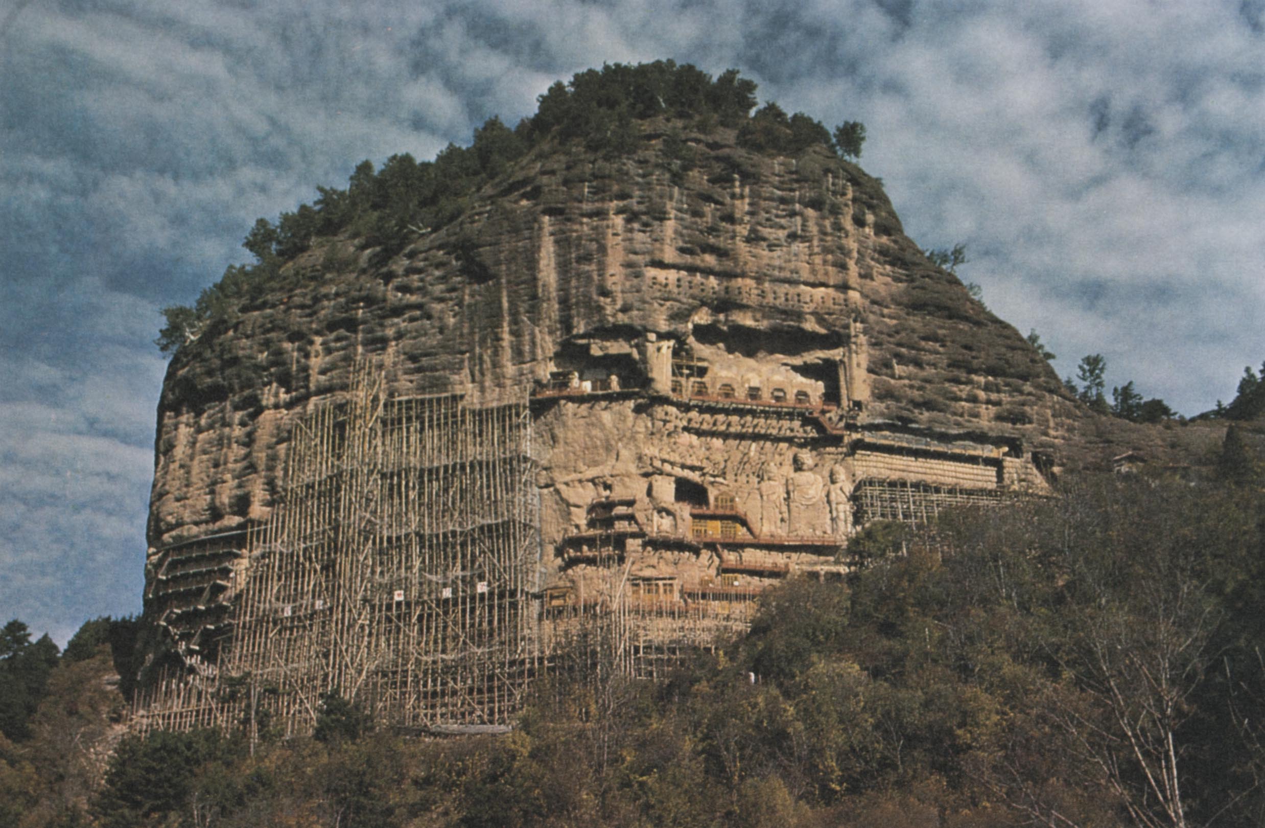 Detail of a postcard gifted with the Silk Road Tour: Music Collection vinyl album, featuring a photograph of the Maijishan Grottoes beneath a sky with a dense layer of clouds.