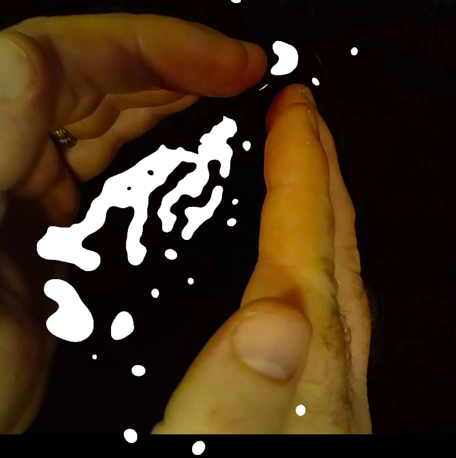 Hands holding a blob form in white against a black background.